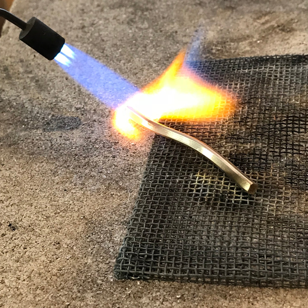 Lamia annealing a gold rod for further rolling
