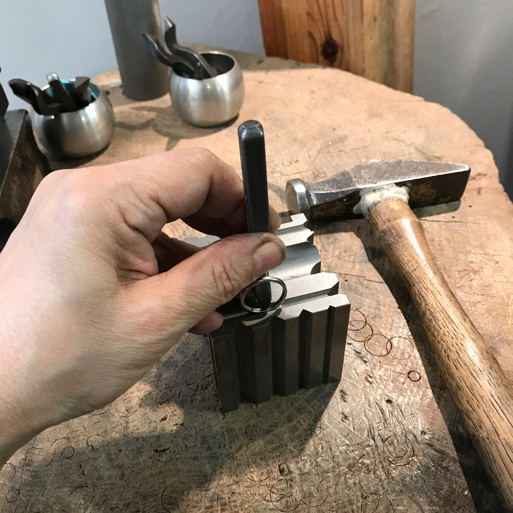 Lamia stamping a hallmark inside a ring